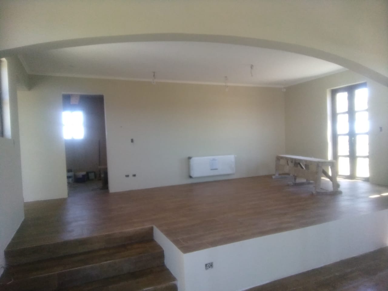Living con desnivel, arco y radiador empotrado