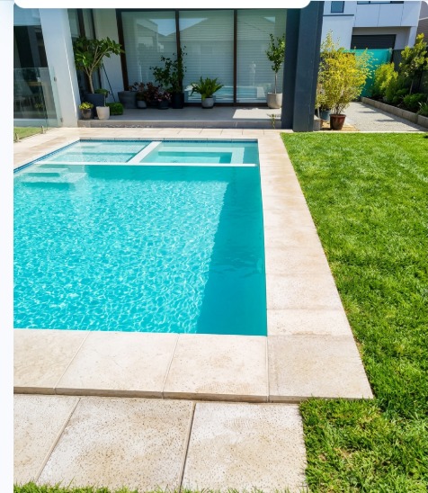 Piscina de hormigón con jacuzzi y paisajismo